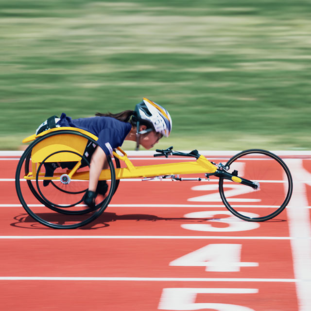 wheel chair racer crossing the finish line in a race