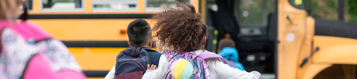 kids running to a school bus